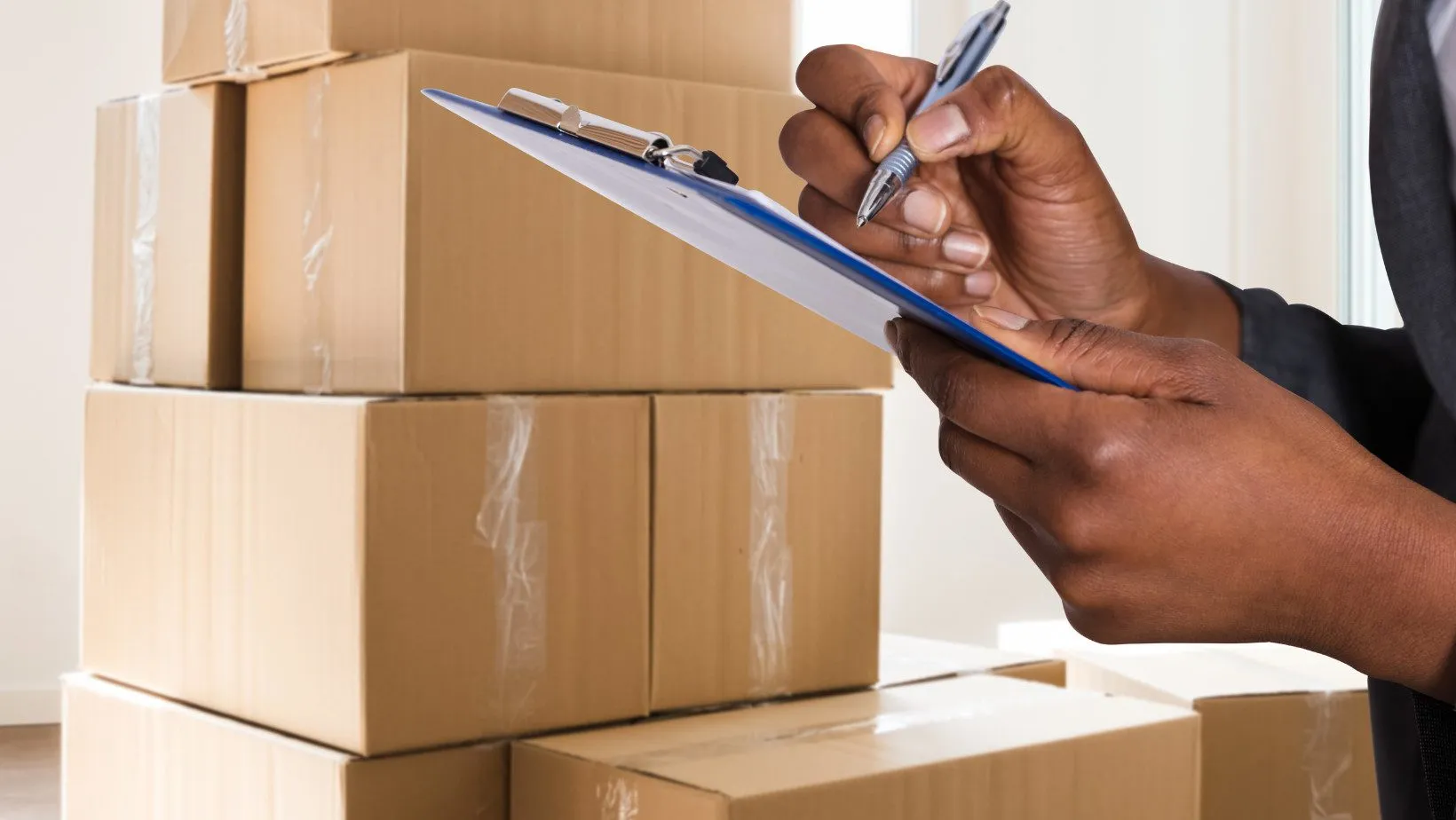 Hands preparing a parcel with kraft paper and shipping supplies